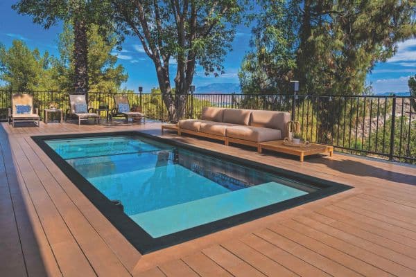 modern swimming pool made from a shipping container installed right into an existing wooden patio