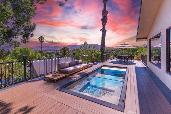 Shipping container pool installed inside an existing deck during a pink California sunset