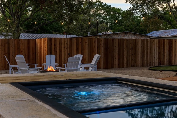 shipping container pool being used as both a pool and a hot tub with spa seating as steps
