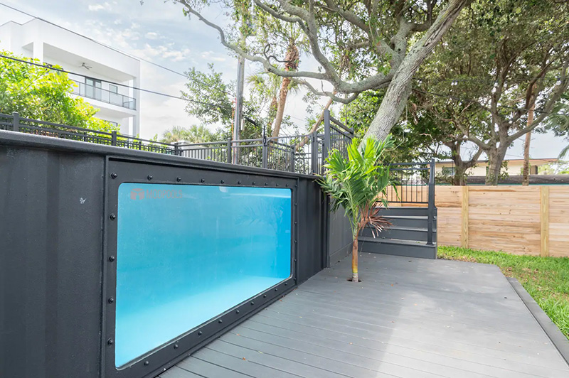 A container pool installed above grund at a Florida Airbnb with a large viewing window on the side